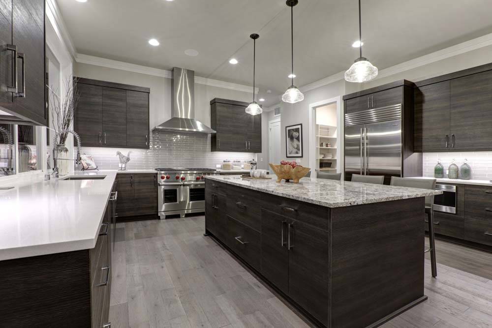 Modern gray kitchen features dark gray flat front cabinets paire
