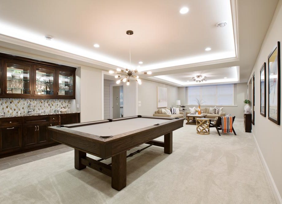Beautiful basement entertaining room with LED lighting in tray ceiling