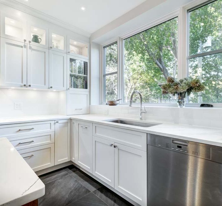 a white-painted kitchen with metallic silver appliances