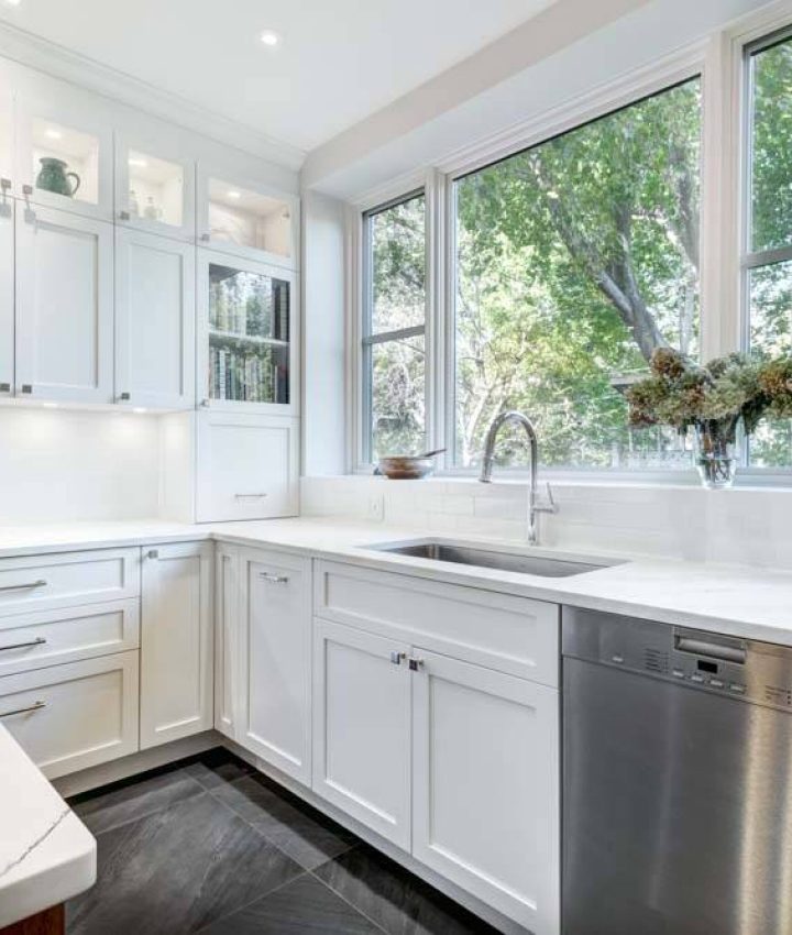 a white-painted kitchen with metallic silver appliances